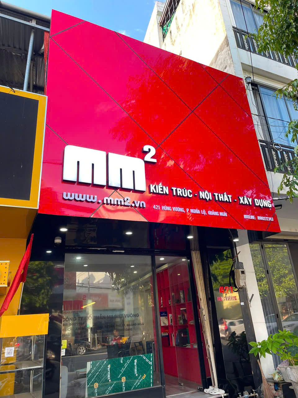 Bảng hiệu nền đỏ chữ trắng trên mặt tiền cửa hàng